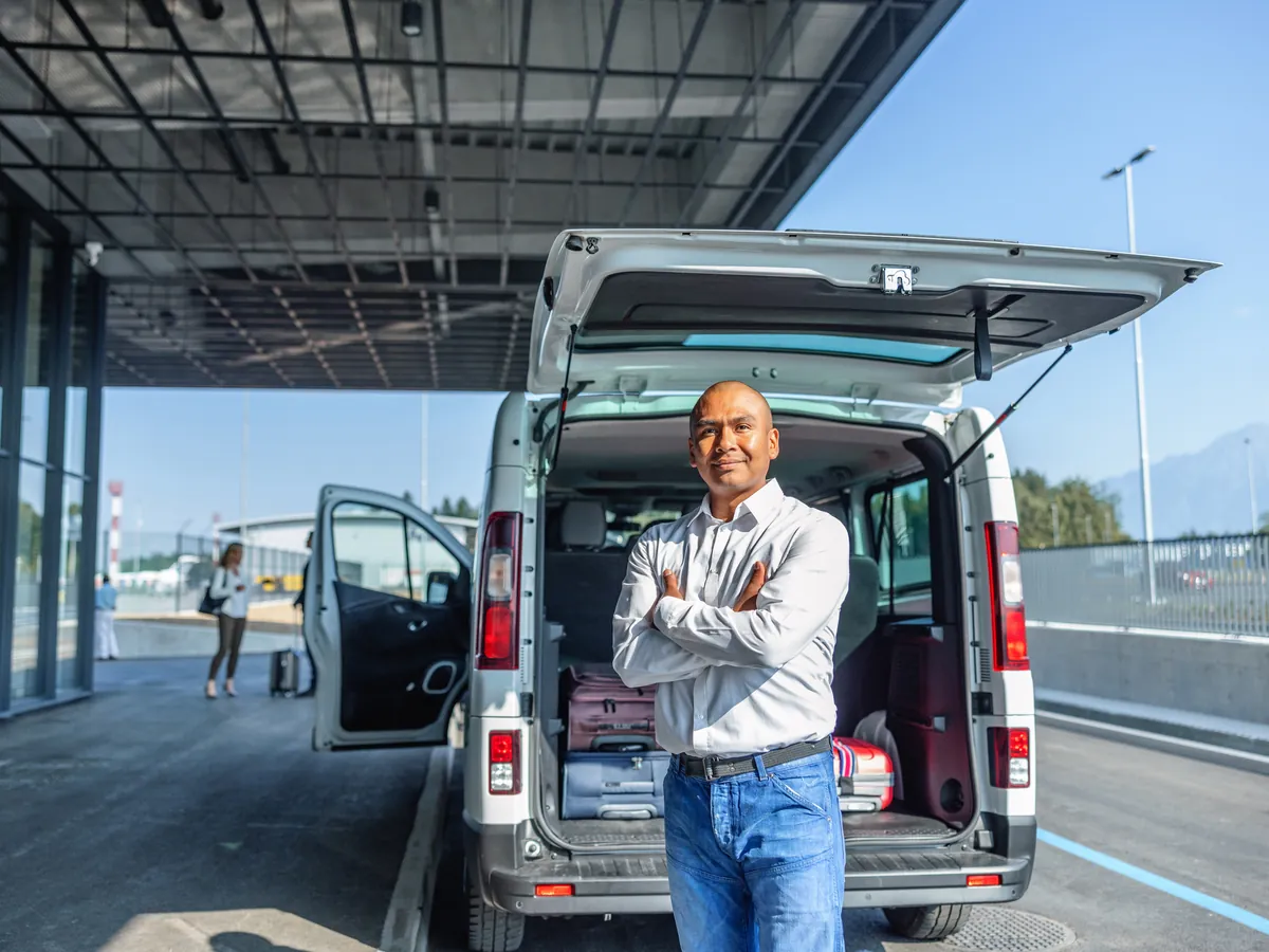 Fahrer steht vor seinem Transporter am Flughafen